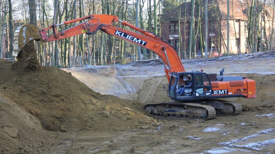 Bagger schüttet in der Baugrube Sand ab