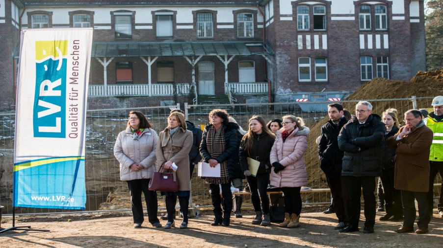 Zuhörer bei der Grundsteinlegung im Hintergrund Haus 12 das in dem neuen Konzept mit intergiert wird.  ©Uwe Weiser/LVR