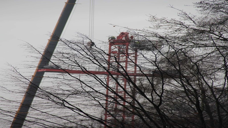 Durch Bäumen sieht man wie der hintere Teil des Auslegers herabgelassen wird.