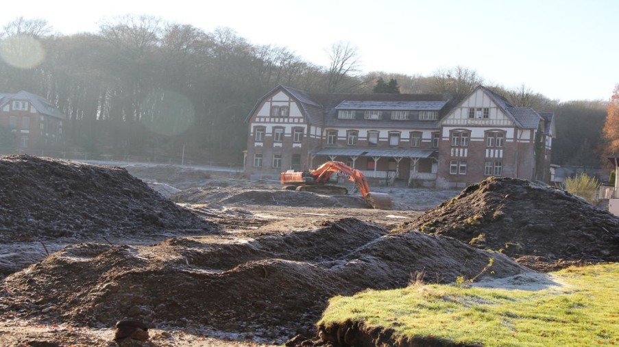 Arbeiten in der Baugrube mit Haus 12 im Hintergrund