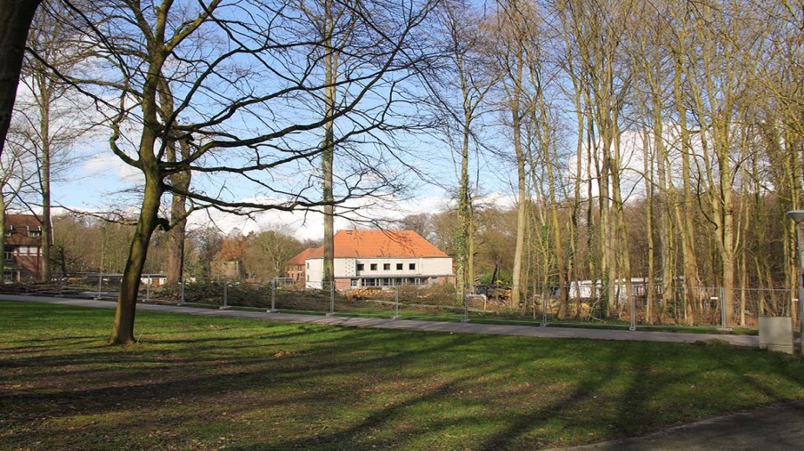 Freier Blick zum alten Festsaal. einige Bäume stehen noch. wo früher ein Wald war ist jetzt im Hintergrund der alte Festsaal zu sehen.
