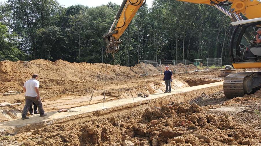 Öffnen des Medienkanals, Durch 2 Fugen erstellte Betonplatte wir durch 4 eingelassenen Stahlösen durch einen Bagger angehoben. 
