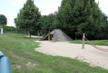 Spielplatz mit Sandkasten, Schaukeln, Holzpyramide und Hängematte