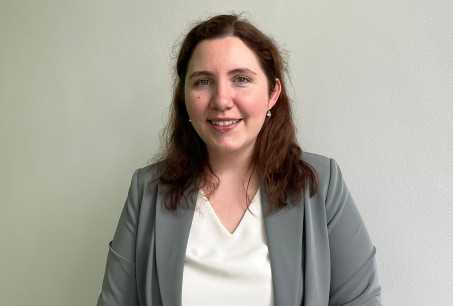 Foto von junger Frau mit braunen Haaren im Blazer. 